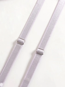 Detailed macro view of light purple elastic bra straps with silver metal adjusters