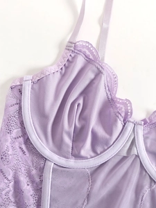 Macro detail of lavender lace corset featuring steel wire support and mesh texture