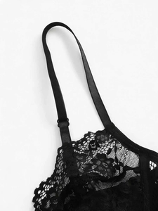 Detail of black floral lace fabric with adjustable thin shoulder straps and fine patterns