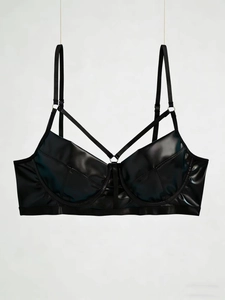 Détail d'un soutien-gorge en cuir PU noir brillant avec lanières croisées et anneaux