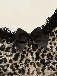 Close-up of leopard print mesh top featuring black lace trim and a central matte bow detail