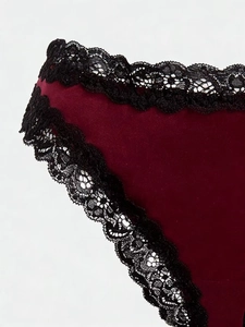 Dettaglio macro di slip in velluto bordeaux con delicato bordo in pizzo nero cigliato