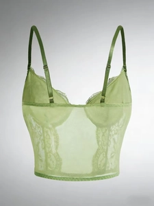 Detailed close-up of grass green lace corset top with sheer mesh and floral patterns