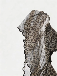 Detail of leopard print lace top featuring sheer mesh fabric and black ruffled lettuce edge