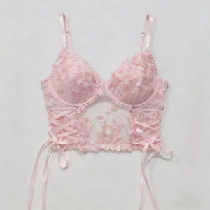 Close-up detail of pink mesh floral embroidery and side lace-up on corset style top