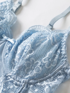 Detailed macro view of light blue lace corset with underwire cups and a satin bow detail