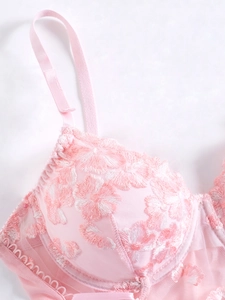 Detailed close-up of pink floral embroidery and delicate mesh texture on camisole top