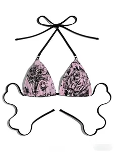 Flat lay of pink gothic bikini top with cross prints and bow-shaped straps on white background