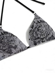Detail of gray bikini top with black rose print and metallic ring connectors