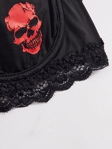Detail of gothic black silk bra with red skull print and delicate lace trim finishes