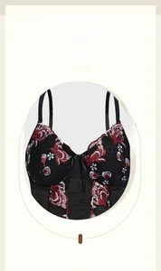 Detail of floral embroidery on mesh corset top with red flowers and satin bow