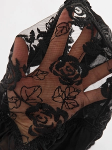 Gros plan sur un tissu en dentelle noire avec broderie de roses et maille transparente