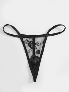 Détail d'un string en dentelle noire avec broderie florale rose et maille transparente chic