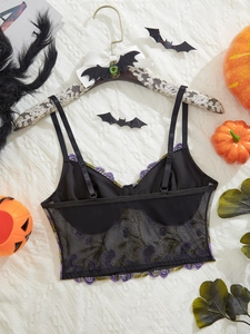 Detail of Halloween mesh bustier with purple flower embroidery and lace texture