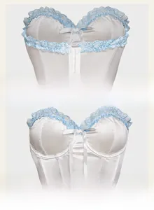 Detailed view of the white satin corset featuring light blue lace trim and a front bow