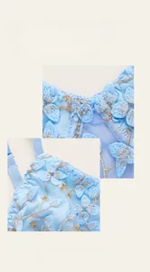 Detail view of light blue mesh bra with delicate floral embroidery and silver edging