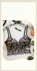 Detail of Halloween mesh bra with floral embroidery and bat charm on wood hanger