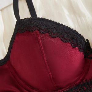 Reggiseno sexy in velluto rosso con pizzo nero e fiocco su sfondo di seta per donne eleganti