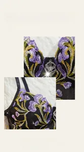 Close-up of black mesh bra featuring purple floral embroidery and silver bat pendant