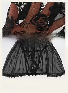 Gros plan sur la lingerie en tulle noir avec broderie rose 3D et bordures en dentelle