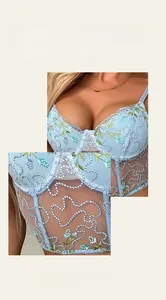 Detailed macro view of delicate floral embroidery on blue sheer mesh lace corset
