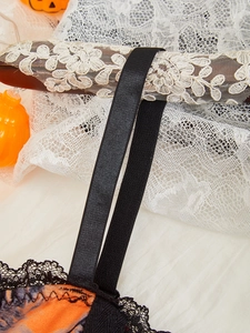 Detail of Halloween camisole showing orange skull print and black lace trim accents