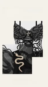 Macro detail of golden snake pendant on black lace corset top with mesh fabric textures