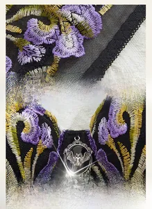 Close-up of gothic lace bra with purple iris embroidery and silver bat pendant