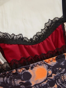 Detail of dark Halloween camisole featuring red fabric, black lace, and skull print