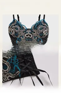Detail of floral embroidery on sheer black corset with lace-up side and cross pendant