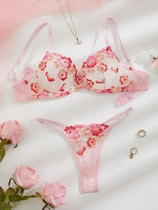 Close-up of pink mesh lingerie set featuring intricate floral embroidery and fine lace details
