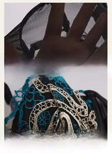 Detailed close-up of snake pattern embroidery on black mesh sheer corset top