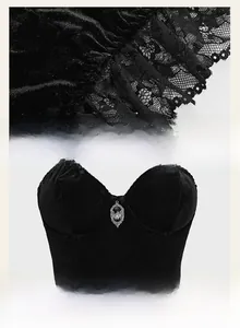 Detailed view of gothic velvet corset with lace edges and a vintage bat pendant