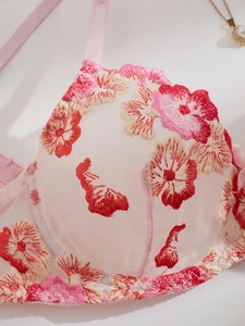 Detail of pink mesh bra featuring premium floral embroidery and delicate lace edges