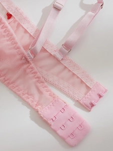 Detail of pink mesh lace bra showing adjustable straps and two-row hook-and-eye closure