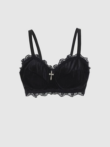 Detail of gothic black velvet bra with lace trim and silver cross pendant