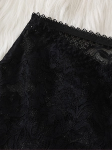 Close-up of intricate black lace floral embroidery and sheer mesh fabric details