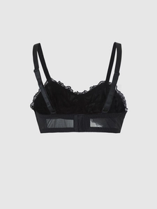 Detail view of the lace trim and adjustable mesh straps on this black velvet corset bra