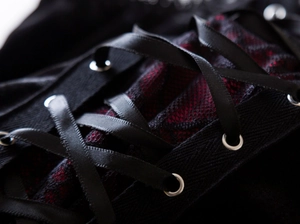 Detail of dark gothic corset with black satin lacing and red mesh lining details