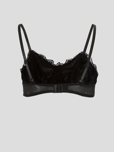 Close-up of black lace bra detail featuring delicate mesh fabric and adjustable straps