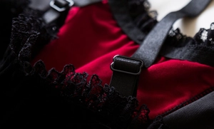 Detail view of red fabric with black lace trim and adjustable elastic shoulder straps