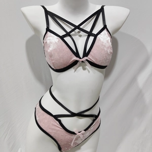 Detail von rosa Samt-Dessous-Set mit schwarzen Kreuzgurten und Schleifenakzenten