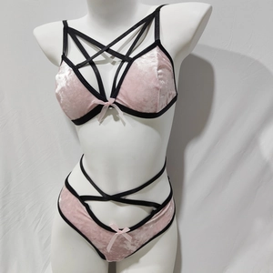 Detail eines rosa Samt-Dessous-Sets mit schwarzen Kontrastträgern und Schleifen auf einer Schaufensterpuppe