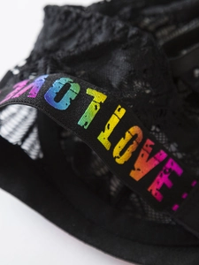 Macro view of black lace lingerie with rainbow gradient LOVE letters on elastic strap