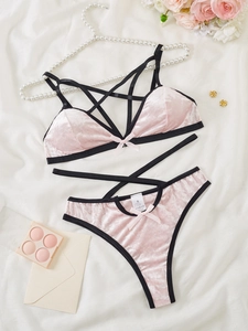 Detailansicht eines rosa Samt-Dessous-Sets mit schwarzem Besatz und Stern-Riemchen