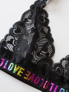 Détail du soutien-gorge en dentelle noire avec lettrage I LOVE arc-en-ciel sur la bande
