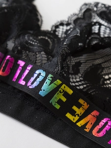 Détail de soutien-gorge en dentelle noire avec lettres LOVE arc-en-ciel sur la bande