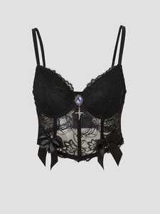 Detail of black lace corset top with floral patterns and a blue gemstone pendant