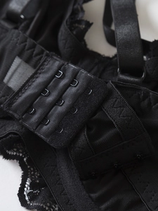 Detailed macro view of the black lace bra featuring a three-row hook and eye back closure