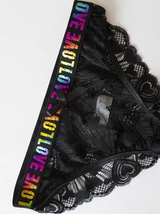 Detail of black lace panties featuring rainbow LOVE lettering and a small bow decoration